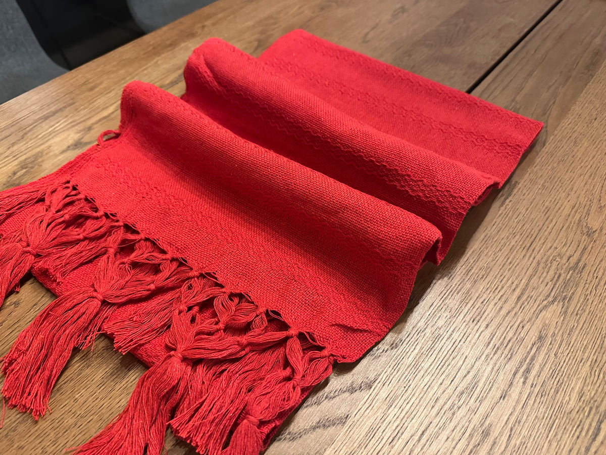 Chile Rojo Mexican rebozo baby wrap in soft folds showing the red knotted fringe | Lola My Love