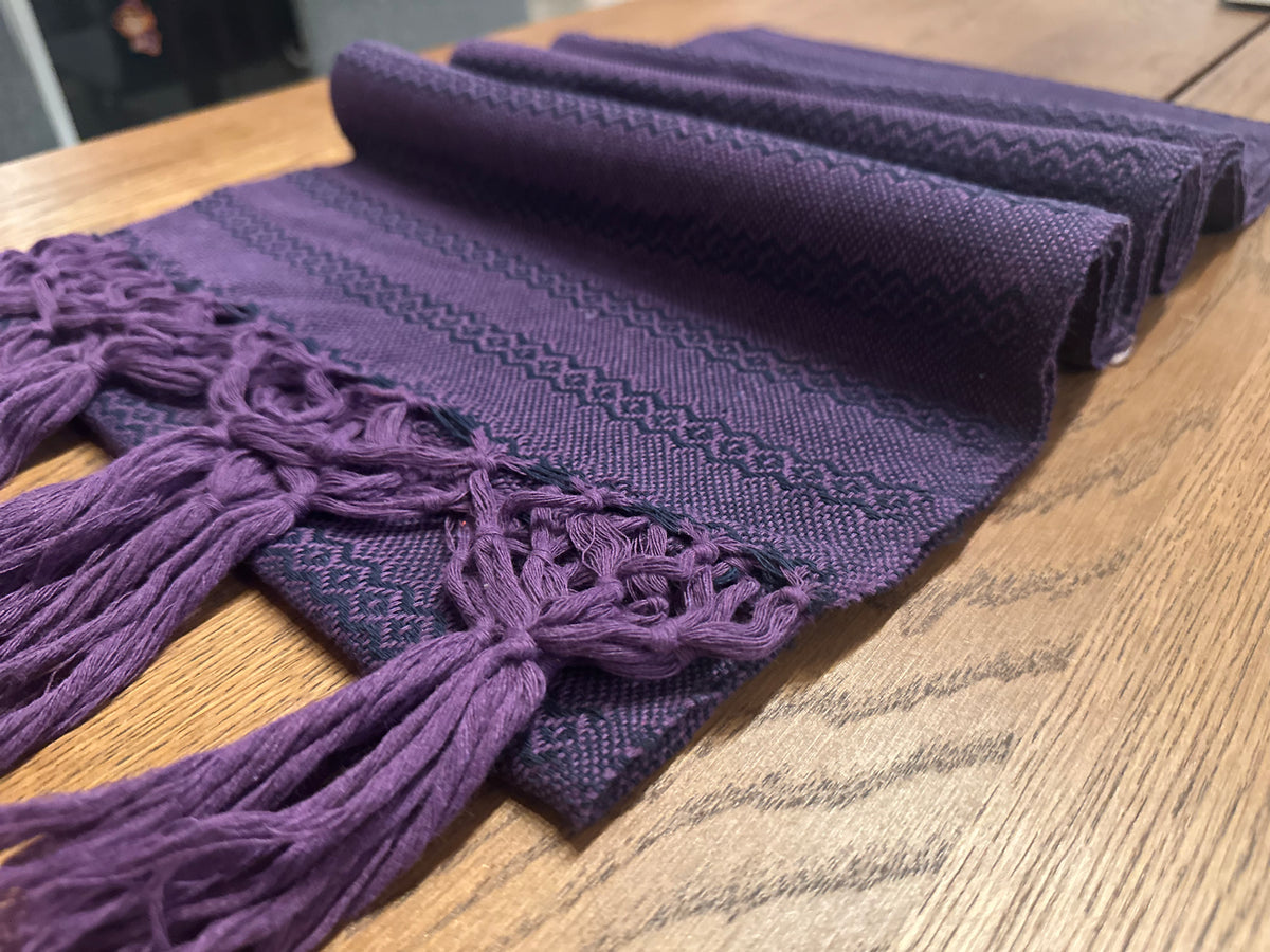Jacaranda Magic Mexican rebozo baby wrap in soft folds showing the purple hand-knotted fringe and navy zigzag weave | Lola My Love