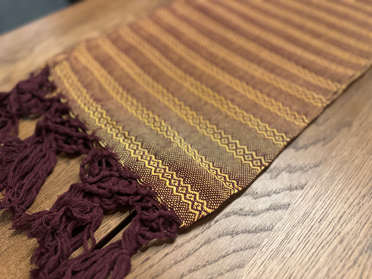 Close-up of the Mole Dorado rebozo's golden-yellow diamond stripes and burgundy hand-knotted fringe | Lola My Love
