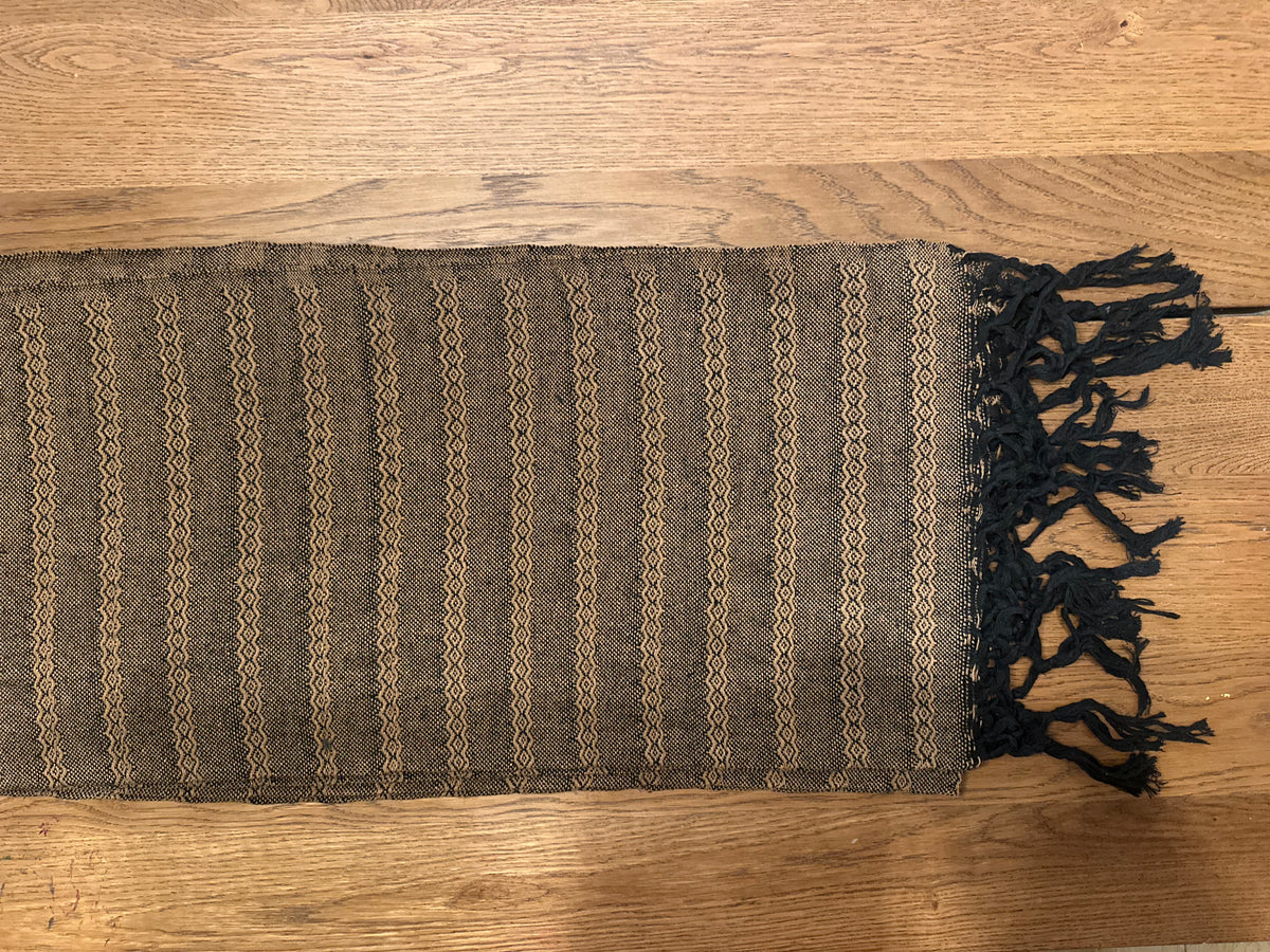 Noche de Mezcal handwoven Mexican cotton rebozo flat lay — black base with golden-tan diamond-zigzag stripes and black knotted fringe | Lola My Love