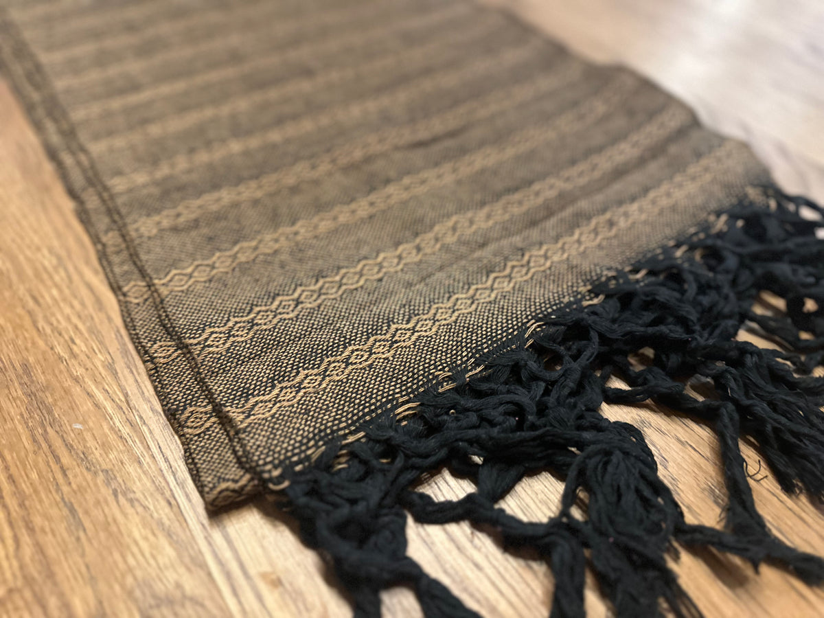 Noche de Mezcal cotton rebozo shawl laid flat at an angle with black knotted fringe and amber stripe border | Lola My Love