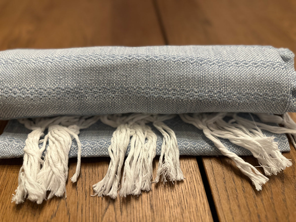 Talavera Azul light blue Mexican rebozo baby wrap rolled with white hand-knotted fringe in front | Lola My Love